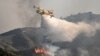 Sebuah pesawat pemadam kebakaran menjatuhkan air di atas api yang membakar dekat desa Vati di bagian selatan pulau Rhodes, Yunani, sekitar 70 kilometer barat daya ibu kota, 25 Juli 2023.