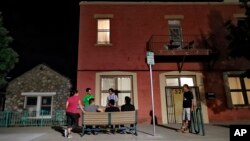 FILE - Migrants socialize outside Annunciation House, June 26, 2018, in El Paso, Texas. A Texas judge ruled against the state attorney general on July 2, 2024, in his effort to shut down a the shelter, which he claimed encourages illegal migration.