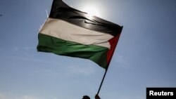 FILE - Houthi followers hold a Palestinian flag during a parade in solidarity with the Palestinians in the Gaza Strip and to show support for Houthi strikes on ships in the Red Sea and the Gulf of Aden, in Sanaa, Yemen, Jan. 29, 2024. 