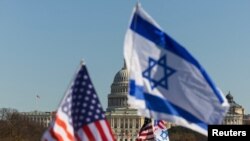 Bendera Israel dan Amerika dikibarkan di dekat Gedung Capitol AS selama unjuk rasa di National Mall di Washington, 14 November 2023. (Foto: Reuters)