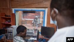 Des ingénieurs du son travaillent lors d'une émission radio dans le studio de Sahara.fm, au Niger, le 20 septembre 2021. AFP / Michele Cattani