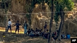 Polisi Perbatasan Myanmar yang mengenakan baju preman beristirahat setelah melarikan diri menyusul serangan oleh tentara etnis Arakan, sementara tentara perbatasan Bangladesh bersiaga di Ghumdhum, Bandarban, Bangladesh, 5 Februari 2024. (Foto: Shafiqur Rahman/AP Photo) 