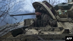 A Ukrainian serviceman of the 47th Mechanized Brigade prepares a Bradley fighting vehicle for combat, not far from Avdiivka, Donetsk region, Feb. 11, 2024, amid the Russian invasion of Ukraine.