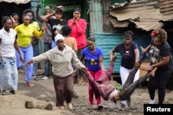 FILE - Women carry an injured supporter of Kenya's opposition leader Raila Odinga during a protest in Nairobi, July 19, 2023. The Odinga supporter was shot during an anti-government protest against the imposition of tax hikes by the government.