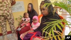 FILE - Then-recently freed Chibok schoolgirls sit with their children at the Army Maimalari Cantonment in Maiduguri, Nigeria, May 4, 2023.