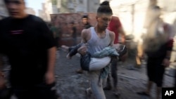 Palestinians evacuate survivors after Israeli airstrikes on buildings in Deir al Balah, Gaza Strip, Nov. 7, 2023.