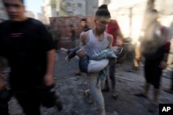 Palestinians evacuate survivors after Israeli airstrikes on buildings in Deir al Balah, Gaza Strip, Nov. 7, 2023.