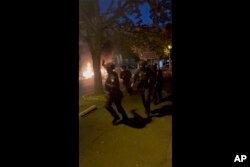 In this image made from video provided, police officers try to control people on a street in Nanterre, France, June 27, 2023.