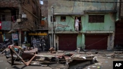 FILE - A Muslim man watches from his house after a shop was demolished in the area that saw communal violence during a Hindu religious procession in New Delhi's northwest Jahangirpuri neighborhood, in New Delhi, India, April 20, 2022.
