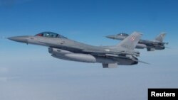 فائل فوٹو: امریکی F-16 طیارے 21 مارچ 2023 کو مالبورک، پولینڈ میں نیٹو میڈیا ایونٹ کے دوران پرواز کر رہے ہیں