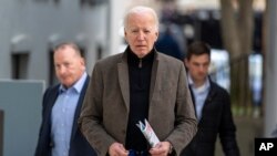 US President Joe Biden walks to speak with reporters as he leaves St. Edmund Roman Catholic Church in Rehoboth Beach, Del., Feb. 17, 2024, after attending a Mass.
