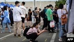 FILE - A woman uses her phone during a job fair in Beijing on Aug. 26, 2022. The unemployment rate among 16- to 24-year-olds in China reached a record high of 21.3% in June 2023, according to official data.