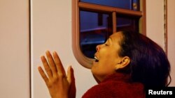 ویانگلی، وینزویلا کی ایک تارک وطن، اپنے زخمی شوہر ایڈورڈ کارابالو کو لے جانے والی ایمبولینس کے باہر رو رہی ہیں۔فوٹو رائٹرز
