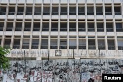 FILE - A barricade covered in barbed wire is placed in front of Lebanon's Central Bank building in Beirut, Lebanon, June 29, 2022.