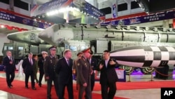 김정은(오른쪽) 북한 국무위원장과 세르게이 쇼이구 러시아 국방장관 일행이 26일 '무장장비 전시회-2023' 전시회장을 참관하고 있다.