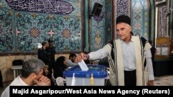 An Iranian man votes at a polling station in Tehran, Iran, during a snap presidential election to choose a successor to Ebrahim Raisi following Raisi's death in a helicopter crash, June 28, 2024.