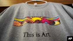 A T-shirt showing the painting displayed outside Leavitt's Country Bakery, is displayed April 13, 2023, in Conway, N.H. Proceeds from the sale of shirts will benefit the art program at a local high school.