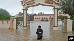 A man wades through flooded street following heavy winds and incessant rains after landfall of cyclone Biparjoy at Mandvi in Kutch district of Western Indian state of Gujarat, June 16, 2023.