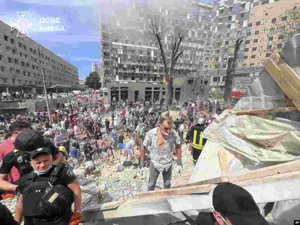 In this photo released by Ukraine's State Emergency Service, rescuers and volunteers work at the site of Okhmatdyt children's hospital hit by a Russian missile, in Kyiv, Ukraine, July 8, 2024.