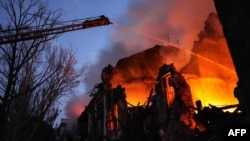 Tim penyelamat memadamkan api kebakaran di gedung tempat tinggal yang hancur akibat serangan rudal Rusia di pusat Mykolaiv, Ukraina, 20 Juli 2023. (Handout / Layanan Darurat Ukraina / AFP)