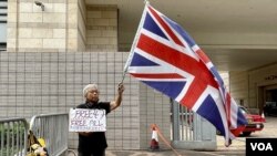 香港民主派初选47人被控国安法下串谋颠覆国家政权案，11月29日开始口头结案陈词，社运人士王婆婆在西九龙裁判法院示威区内，独自一人手持英国旗及标语，要求释放47、释放所有政治犯 (美国之音/汤惠芸)