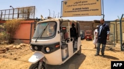 Wafanyakazi wakiunganisha bajaji ya umeme katika kiwanda kilichopo Khartoum April 19, 2022. Picha na ASHRAF SHAZLY / AFP.