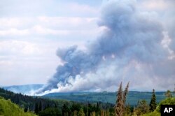 Smoke billows from the Donnie Creek wildfire burning north of Fort St. John, British Columbia, Canada, July 2, 2023.
