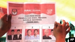Seorang petugas pemilu memegang surat suara yang menunjukkan suara capres Prabowo Subianto dan pasangannya Gibran Rakabuming Raka, saat penghitungan suara di TPS setelah pemilu di Jakarta, Rabu, 14 Februari 2024. (AP/Tatan Syuflana)