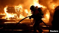 Crews extinguish vehicle fires during clashes between protesters and police, after the death of a 17-year-old teenager killed by a French police officer during a traffic stop, in Nanterre, France, June 28, 2023.