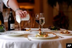 FILE - A chef pours roasted onion soup for reveillon at the Grill Room of the Windsor Court Hotel in New Orleans, Dec. 7, 2012. Reveillon, a Creole custom, stems from the French tradition of eating a lavish meal after midnight Mass on Christmas Eve.