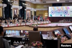 India's Prime Minister Narendra Modi (on screen) addresses the G20 foreign ministers' meeting in New Delhi on March 2, 2023. OLIVIER DOULIERY/Pool via REUTER