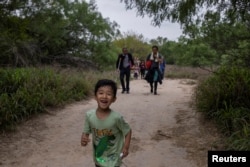 一名5岁来自中国的男童和他的家人渡过美墨边境的格兰德河走在美国德克萨斯州的道路上。（2023年4月5日）