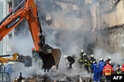 FILE - Rescuers work on the rubble of a damaged residential building in Uman, in the Cherkasy Oblast, central Ukraine, on April 28, 2023, after Russian missile strikes targeted several Ukrainian cities.