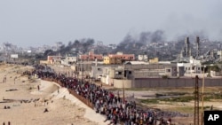 Warga Palestina menunggu truk bantuan menyeberang di tengah Jalur Gaza pada Minggu, 19 Mei 2024. (AP Photo/Abdel Kareem Hana)