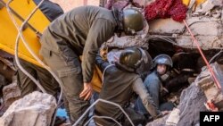 Rescue workers search for survivors in a collapsed house in Moulay Brahim, Al Haouz province, Morocco, after an earthquake, Sept. 9, 2023.