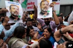 Congress party workers distribute sweets as they celebrate the Supreme Court of India's verdict in a 2019 defamation case against party leader Rahul Gandhi, outside party office in Mumbai, India, Aug. 4, 2023.