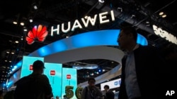 资料照片：在北京举行的 PT 博览会上，与会者走过中国技术公司华为的 5G 服务展示。(2019年10月31日）