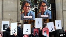 FILE - In this Jan. 13, 2022 photo, colleagues of academic Fariba Adelkhah hold placards in Paris in support following Iran's decision to send her back to prison after a period of house arrest. On Feb. 10, 2023, she was released from prison. 