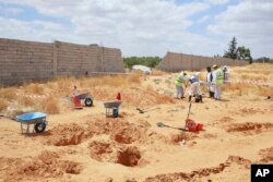 FILE - Pegawai Kementerian Kehakiman Libya menggali kuburan massal di kota Tarhouna, Libya, Selasa, 23 Juni 2020. (AP/Hazem Ahmed)