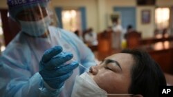 រូបឯកសារ៖ ស្ត្រីម្នាក់ធ្វើតេស្ត​កូវីដ នៅរាជធានីភ្នំពេញ កាលពីថ្ងៃទី២ ខែសីហា ឆ្នាំ២០២២។