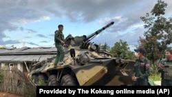 FILE - Members of an ethnic armed forces group, known as the Three Brotherhood Alliance, check an army armored vehicle the group allegedly seized from Myanmar's army outpost on a hill in Hsenwi township in Shan state, Nov. 24, 2023.