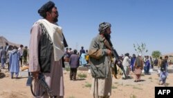 Pasukan kemanan Taliban berjaga di saat para warga mengebumikan korban serangan di masjid Syiah di distrik Guzara, provinsi Herat, pada 30 April 2024. (Foto: AFP/Mohsen Karimi)