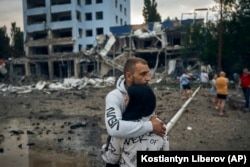 FILE - A couple reacts after the Russian shelling in Mykolaiv, Ukraine, Wednesday, Aug. 3, 2022. According local media, supermarket, high-rise buildings and pharmacy were damaged. (AP Photo/Kostiantyn Liberov)