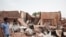 A man walks by a house hit in recent fighting in Khartoum, Sudan, April 25, 2023.