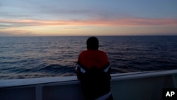 រូបឯកសារ៖ ជនចំណាកស្រុក​សូម៉ាលី​ឈ្មោះ Amsa អាយុ១៦ឆ្នាំ ឈរ​មើល​ព្រះអាទិត្យលិច​ នៅ​កោះ Lampedusa នៃ​កោះ Sicilian ប្រទេស​អ៊ីតាលី កាលពីថ្ងៃទី៧ ខែតុលា ឆ្នាំ២០១៣។ 