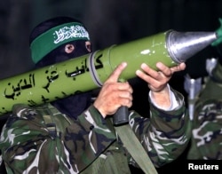 ARHIVA - Maskirani palestinski borac pokreta Hamas drži antitenkovsko ručno oružje, dok zauzima poziciju oko grada Gaze, 22. aprila 2002.