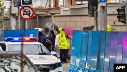 Policemen (in yellow) stand guard on Wulumuqi road, named for Urumqi in Mandarin, in Shanghai on Nov. 29, 2022, two days after rare protests against China's zero-COVID policy.