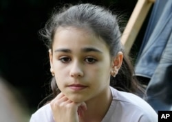 มิลานา มิเนนโก วัย 9 ปีจากยูเครน นั่งมองเหม่อขณะให้สัมภาษณ์กับสื่อเอพี ที่กรุงวอร์ซอ ประเทศ โปแลนด์ เมื่อวันที่ 7 มิ.ย. 2023 (AP)