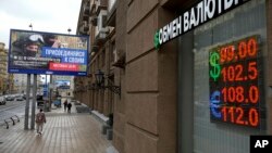 FILE - People walk near a currency exchange office next to an army recruitment billboard amid Russia's war on Ukraine, in Moscow, Aug. 14, 2023. 