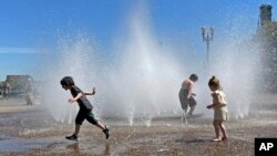 Children play in a fountain to cool off in Portland, Oregon, May 12, 2023. A heat wave this weekend could surpass daily records in the Pacific Northwest, a historically temperate region that has grappled with scorching summer temperatures in recent years.